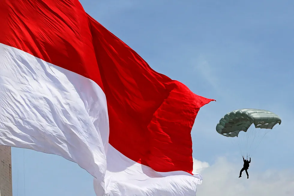Flag day: an Army soldier parachutes near a giant Indonesian in Jakarta