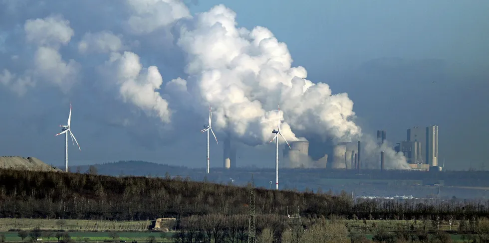 Wind turbines in front of a coal-fired power plant in Neurath, western Germany.