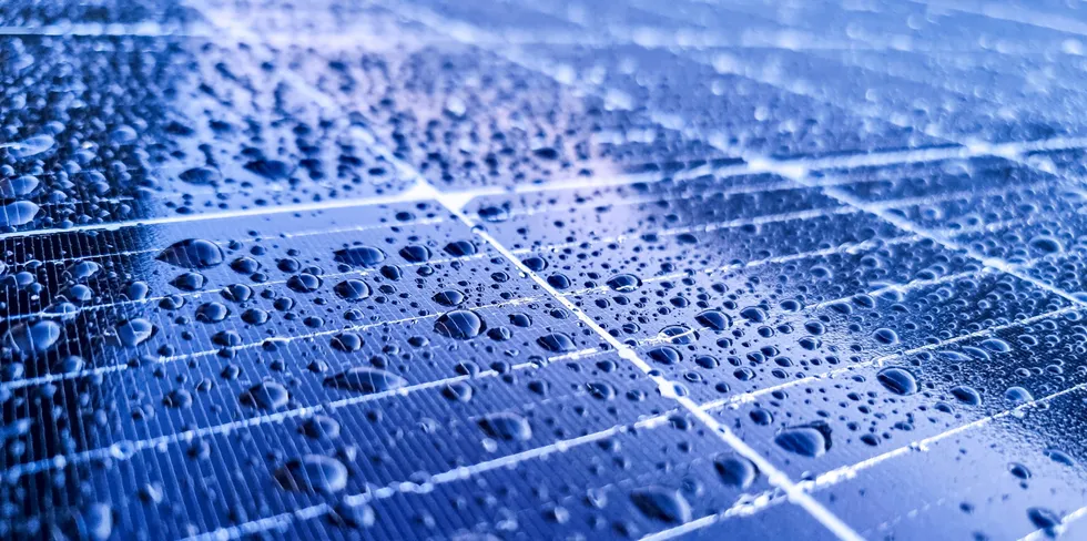 Rain drops on the surface of a solar photovoltaic panel.