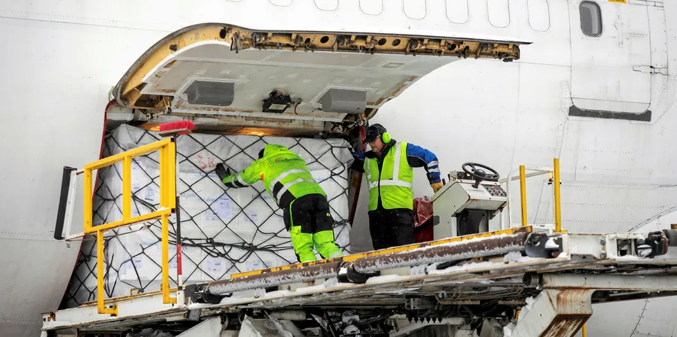 Yngve Ramberg Skaug gir den siste av 14 paller med norsk laks et siste dytt inn i jumbo-jeten som skal fly til Kina med en mellomlanding i Kazakhstan for etterfylling av drivstoff. Turen til Kazakhstan tar rundt 4,5 timer, mens neste legg tar 5. Vernon C.H. Thor (t.h.) styrer liften.