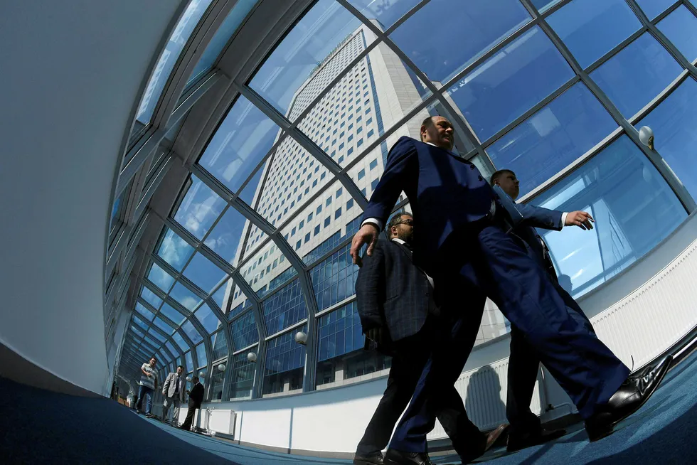 Standing tall: businessmen walk past the headquarters of Gazprom in Moscow
