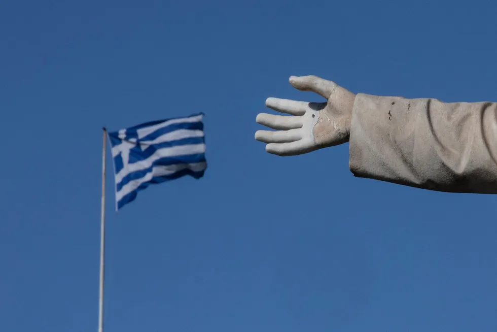 Reaching out: a Greek flag flies behind a statue in the capital Athens