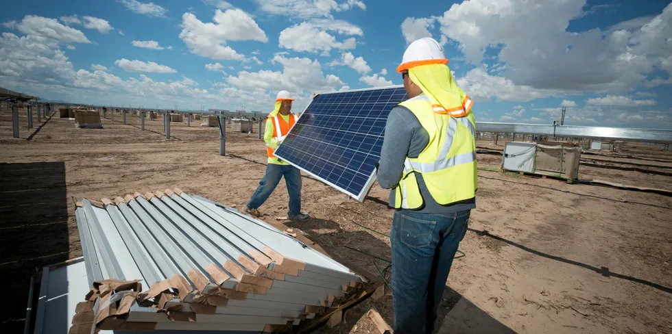 Workers install PV panels for Swinerton, one of largest solar EPC players in the US