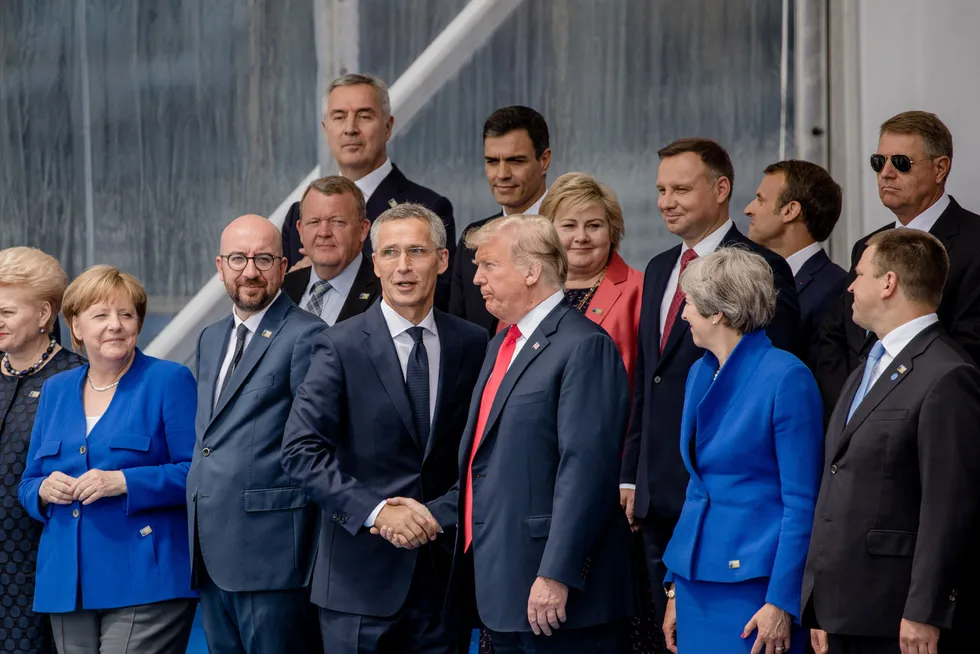 Generalsekretær Jens Stoltenberg tar president Donald Trump i hånden mens stats- og regjeringslederne samles til familiefoto. Toppmøtet i Brussel i 2018 ble det mest dramatiske og kaotiske i Natos historie.