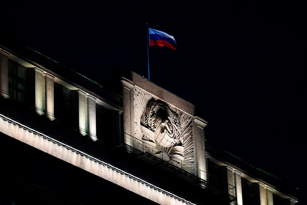 Out of the dark: The Russian national flag flutters on top of the country's parliament Duma in central Moscow