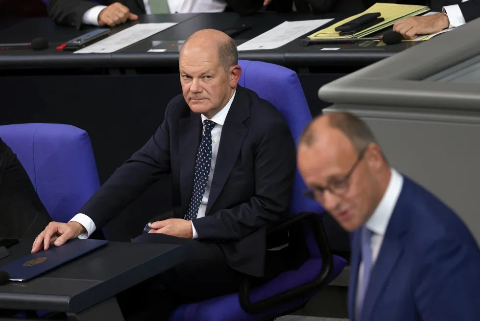 German Chancellor Olaf Scholz (l) stares at opposition leader Friedrich Merz (r) in parliament.