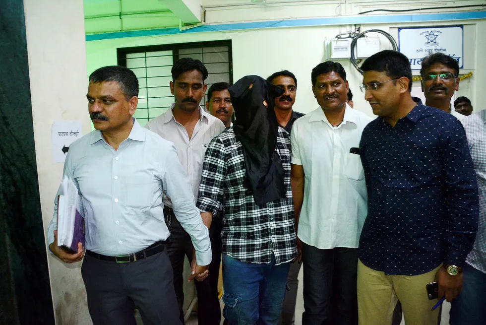 Mesterhjernen bak et nettverk av indiske svindelsentre ble arrestert da han returnerte fra Dubai i helgen. Sagar Thakkar valgte å spille på en pressekonferanse med tildekket hode. Foto: AFP/NTB Scanpix