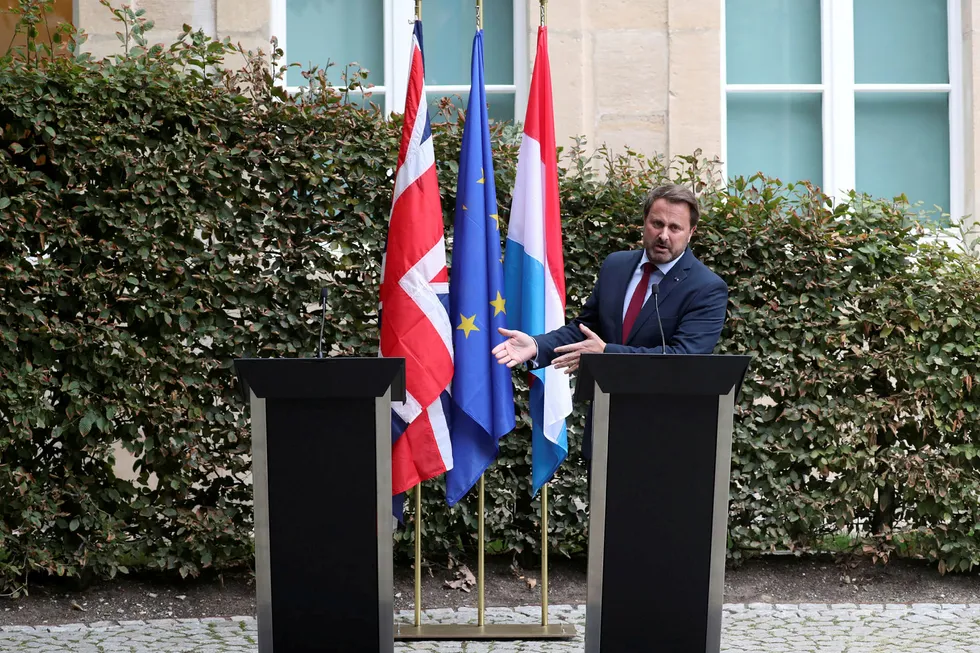 Luxembourgs statsminister Xavier Bettel peker på den tomme talerstolen der hans britiske kollega Boris Johnson skulle stått etter møtet mellom de to mandag.