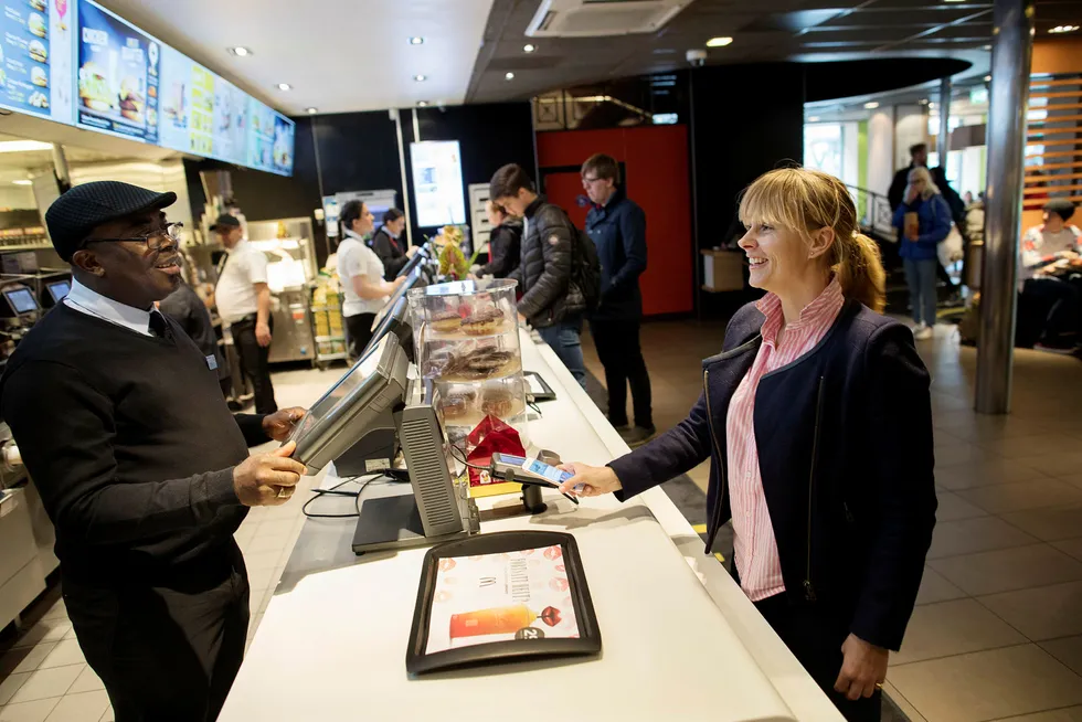 Vipps’ nestsjef Elisabeth Haug lanserte denne uken en ny pilot for mobilbetaling i butikk hos McDonalds i Oslo. Hun betaler ved å sveipe over terminalen, og bekrefter med tommelen på Iphonen. Foto: Øyvind Elvsborg