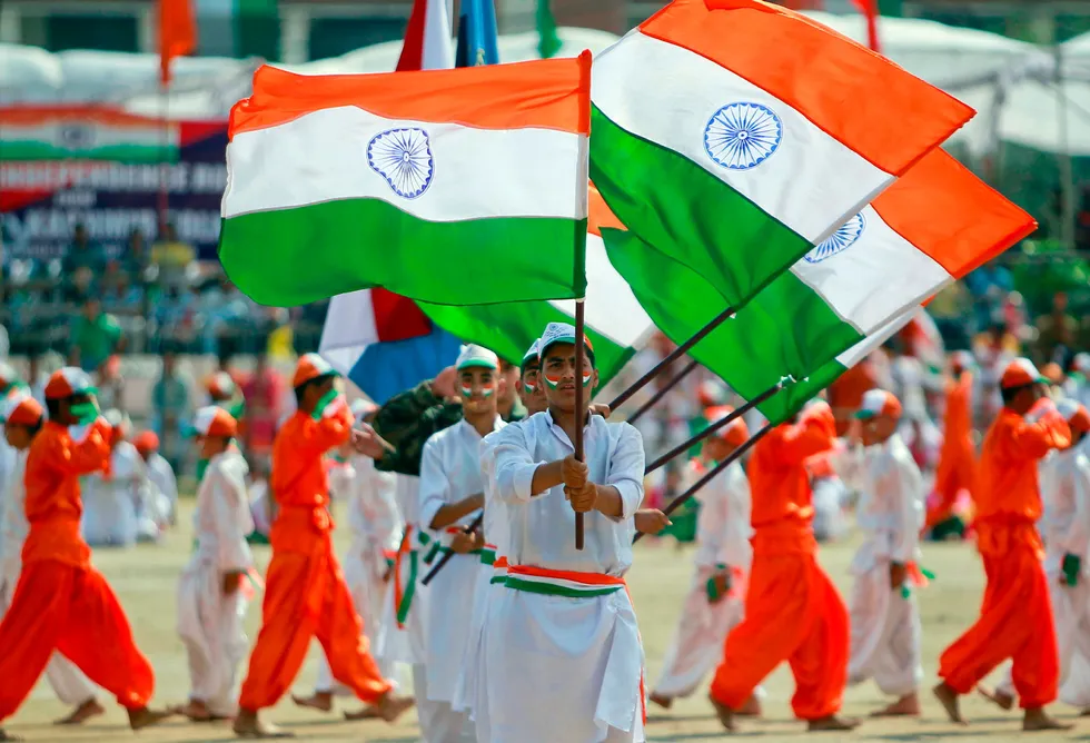 Celebration: students wave India's national flag as they perform during the nation's Independence Day festivities