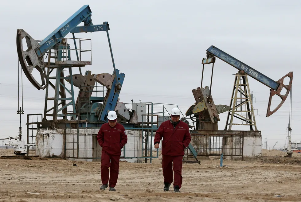 Taps open: workers walk past oil pumps at the Ozen oil and gas field in the Mangistau region of Kazakhstan