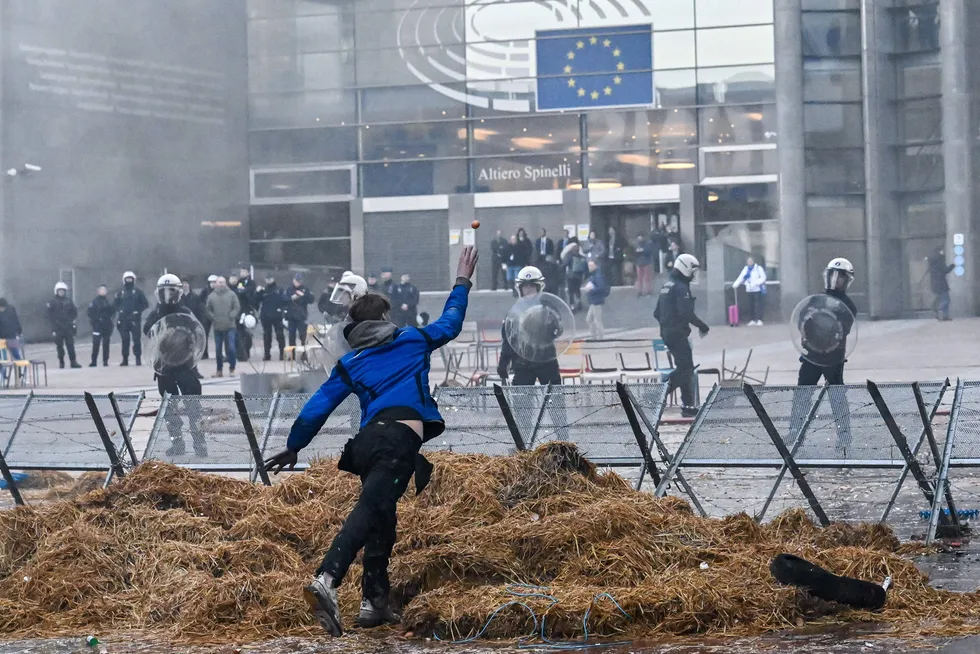Sint bonde kaster egg mot politiet utenfor Europarlamentet i Brussel. Nå letter EU på klimakrav til bøndene.