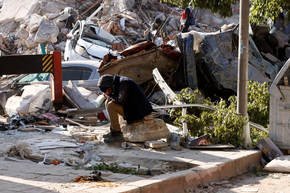 Destroyed: A man sits on rocks with hands on his face surrounded by rubble following the earthquake in Hatay, Turkey.