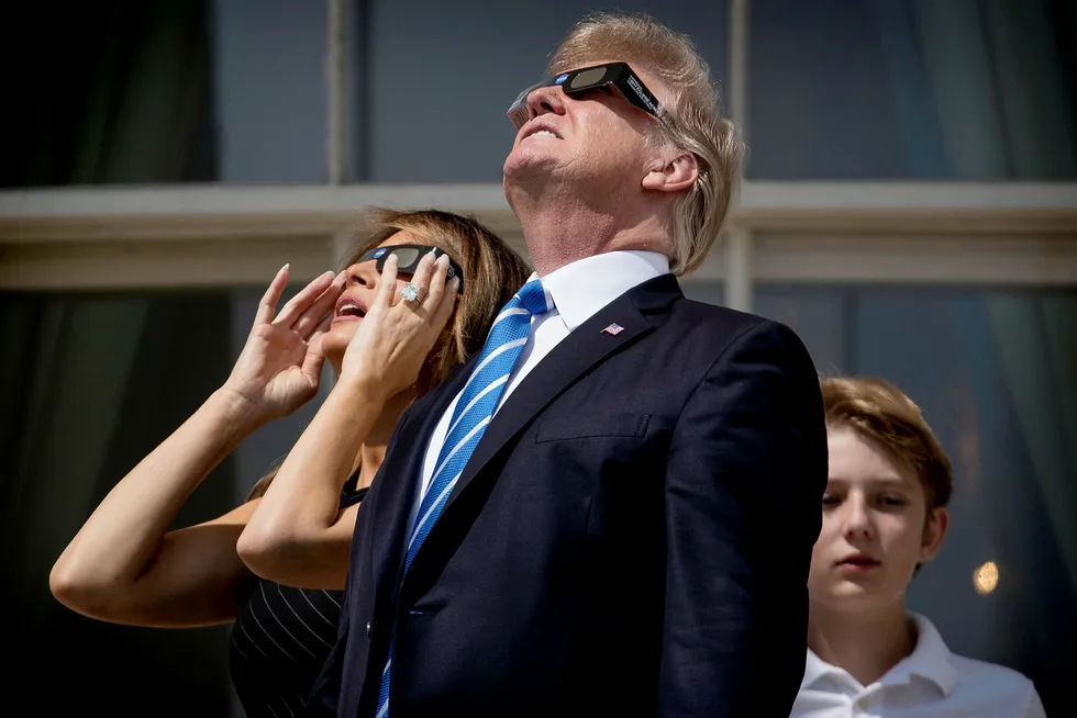 President Donald Trump under solformørkelsen mandag sammen med konen Melania og sønnen Barron. Nå vil Trump forbedre forholdet til både republikanere og næringslivet gjennom skattereform. Andrew Harnik/AP/NTB scanpix