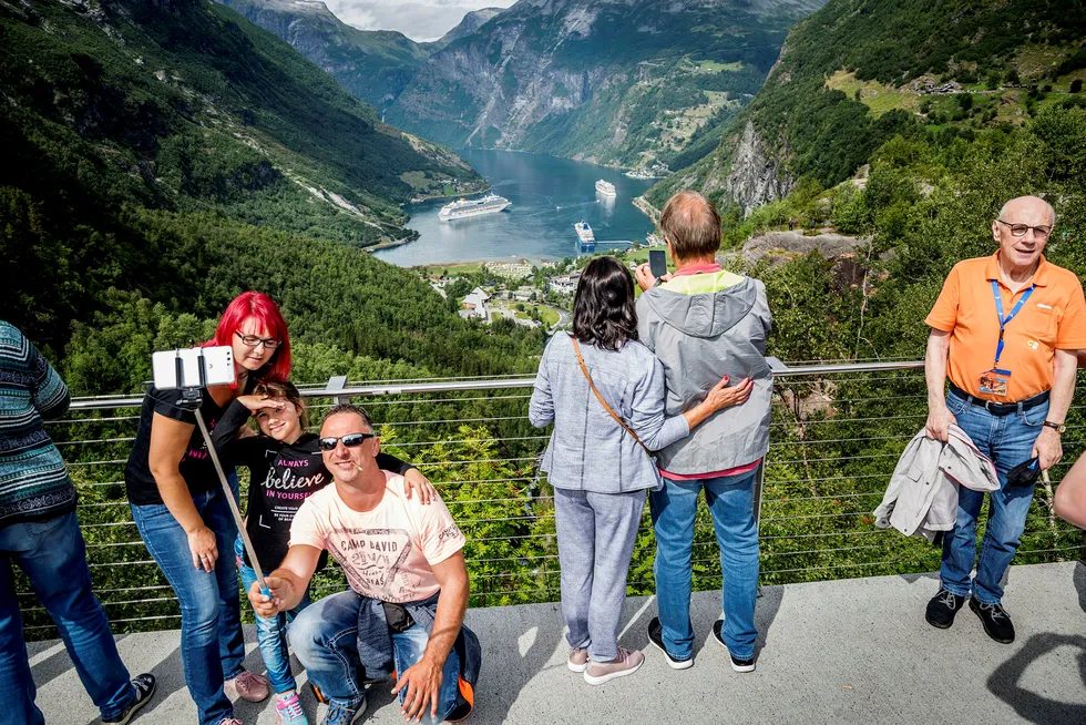 Regjeringen innfører en ny kontantstøtteordning for reiselivet. Her turister foran utsikten over Geirangerfjorden.