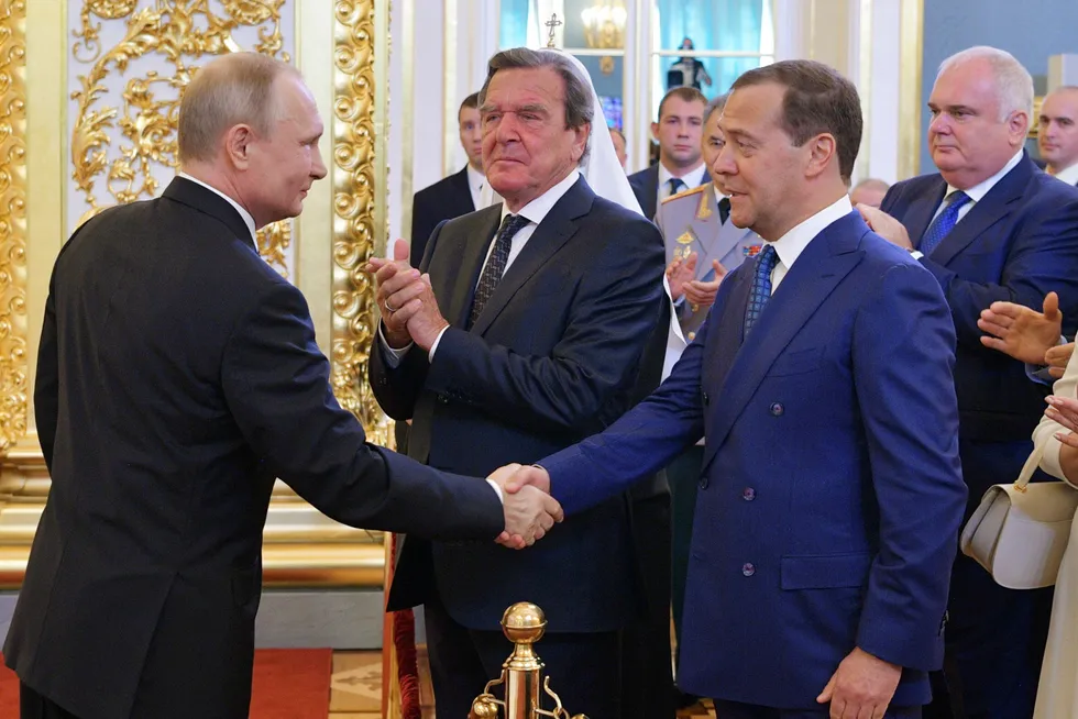 Hand shake: former German chancellor and Rosneft chairman Gerhard Schroeder is pictured between Russian President Vladimir Putin and former Prime Minister Dmitry Medvedev in May 2018