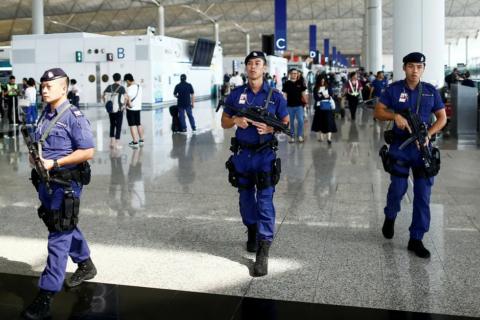 Bevæpnet politi patruljerer nå på flyplassen i Hongkong.
