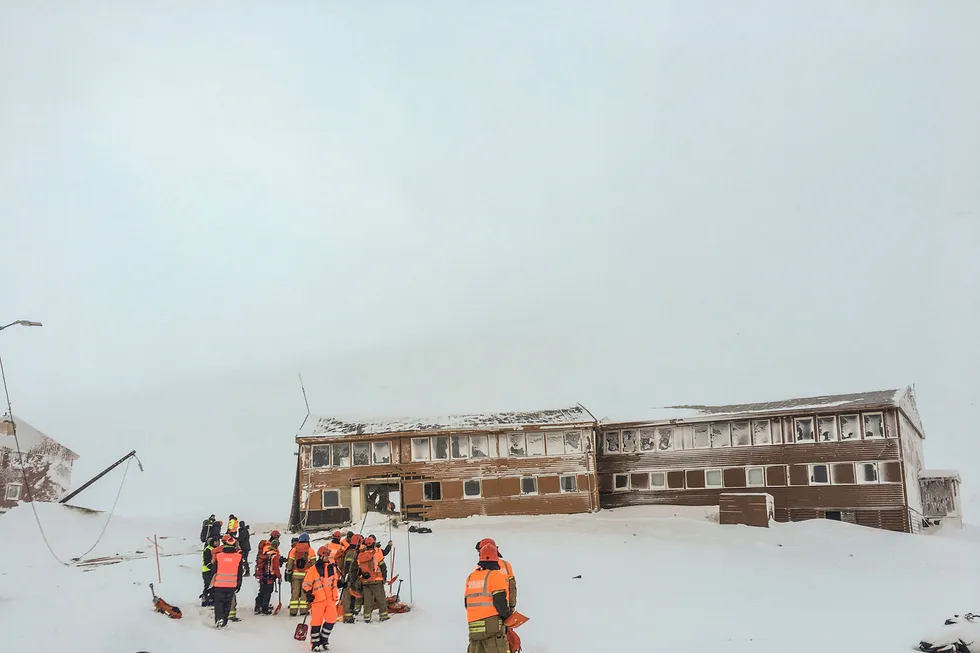 Redningsmannskaper på stedet der et snøskred har gått over vei 228 i Longyearbyen på Svalbard og rammet minst én bygning som ligger nærmest inn mot Sukkertoppen tirsdag. Foto: Stringer/NTB Scanpix
