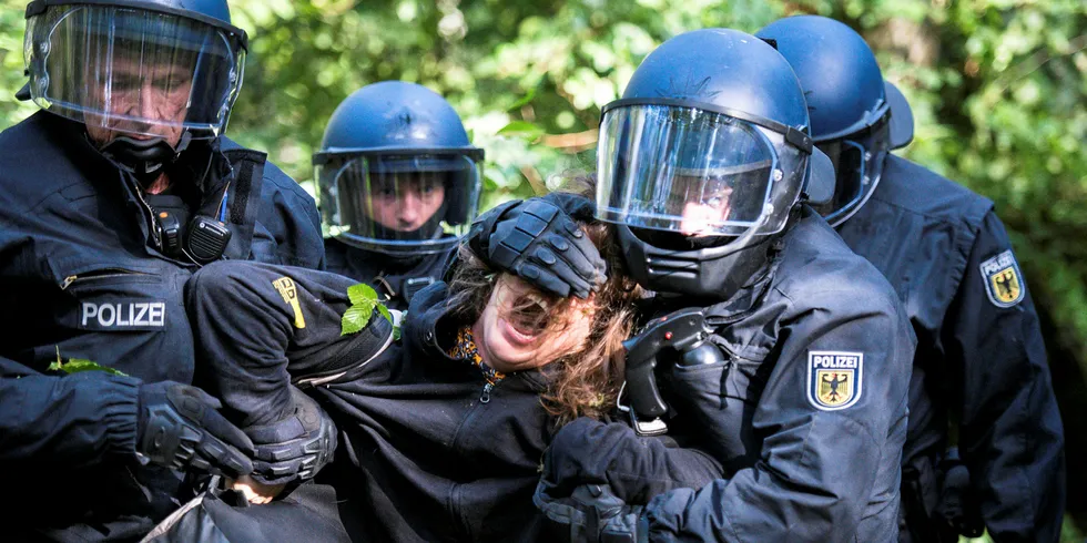 Policemen carry away an environmental activist at the Hambacher Forst forest that is to be deforested for enlargement of a lignite open-pit mine near Kerpen, western Germany.