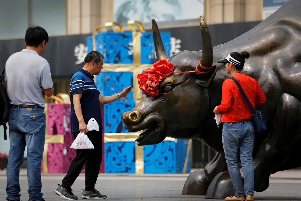Det er ikke mye som minner om et «bull market» i Asia, slik denne oksen utenfor et kjøpesenter i Shanghai er ment å illustrere. Det er frykt for at handelskrigen mellom Kina og USA skal spre seg til andre land i Asia. Foto: Andy Wong/AP/NTB Scanpix
