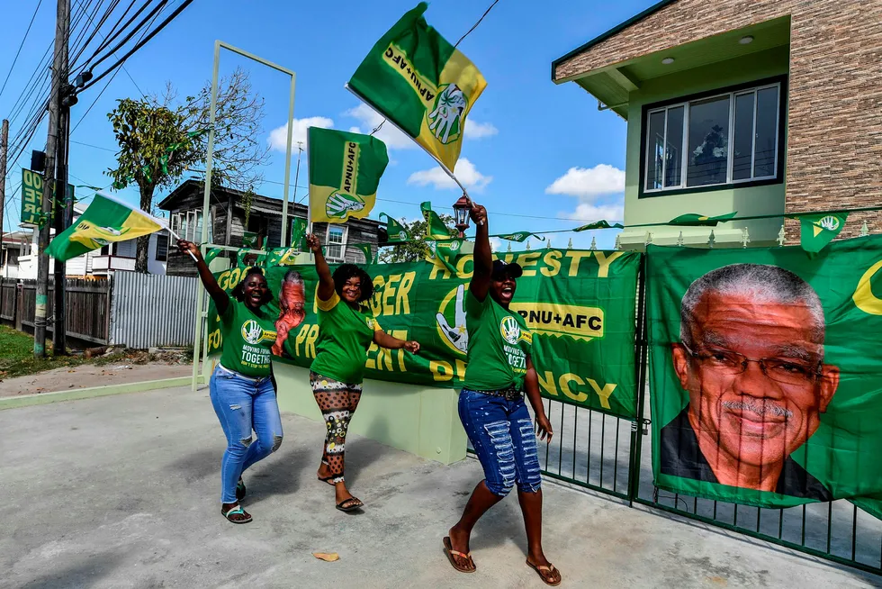 Good times: supporters of presidential incumbent David Granger wave flags in Georgetown, Guyana one day before voting. A new oil boom may reshape an ethnically divided political landscape in one of South America's poorest nations