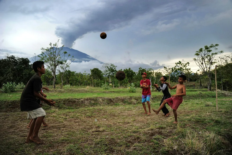 Agungs aktivitet har minsket. På bildet leker barn ubekymret for hva som kan skje hvis det skulle bli et betydelig utslipp. Foto: Sonny Tumbelaka/Afp photo/NTB scanpix