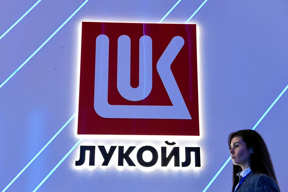 Improvements: a woman walks past the logo of oil producer Lukoil at an economic forum in St Petersburg in Russia