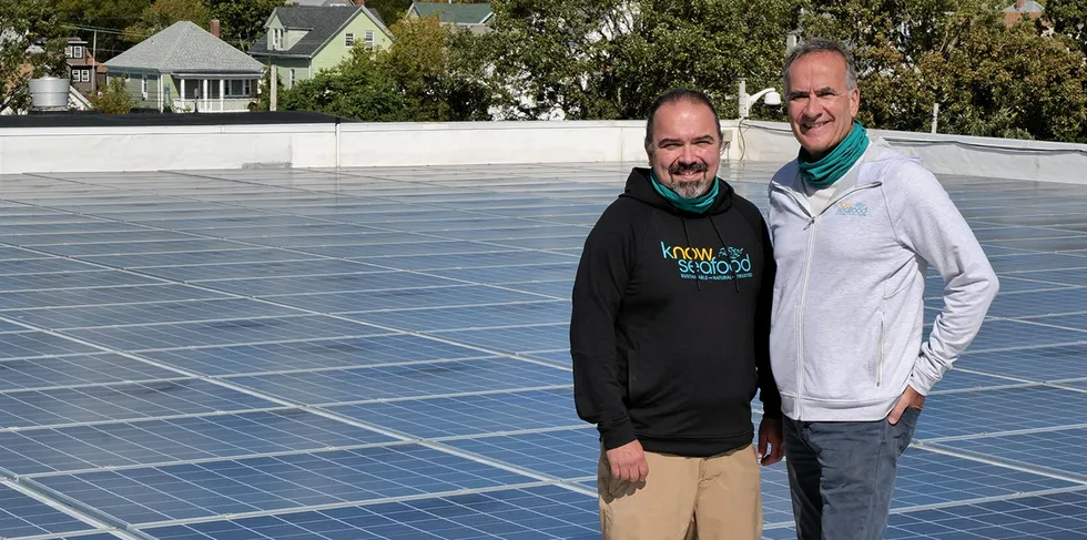 From left to right: KnowSeafood co-founders Paul Neves and Dan McQuade with solar panels on the roof of KnowSeafood's energy supplier in New Bedford, MA. The company's cold storage facility has net-zero carbon emissions.