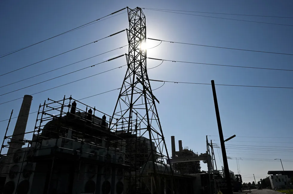 Power lines and a natural gas-fired electric power generating unit in California.