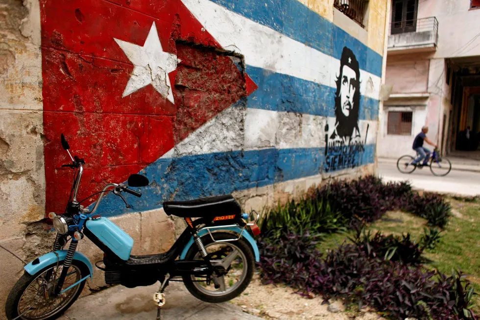 Local attractions: a motorcycle is parked next to a wall painted with a Cuban flag and an image of revolutionary hero Che Guevara in Havana, Cuba