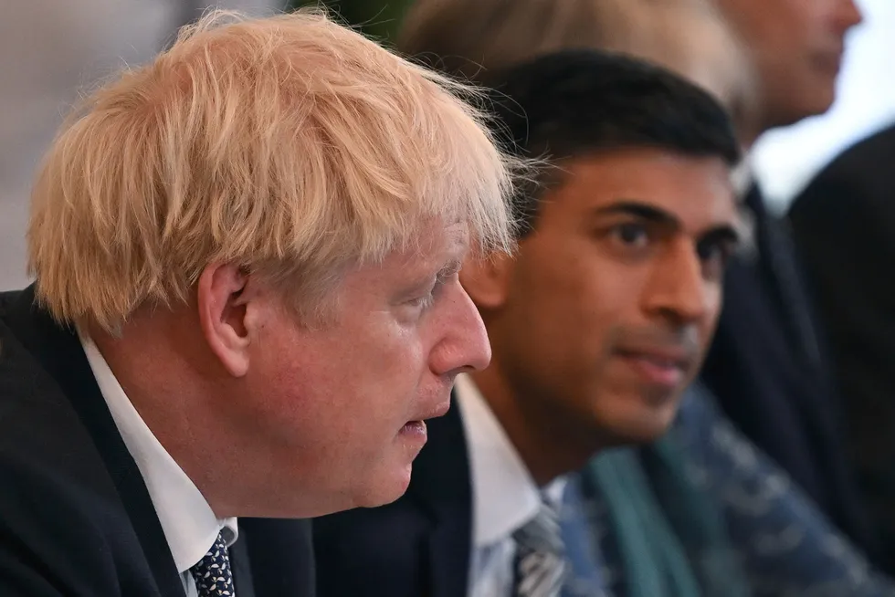 Storbritannias finansminister Rishi Sunak (i bakgrunnen) trekker seg fra regjeringen i protest mot statsminister Boris Johnson.