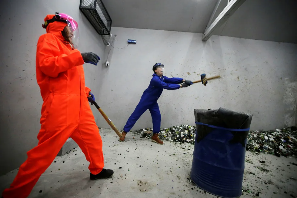 A couple wearing protective gir smash wine bottles in an anger room in Beijing, China January 12, 2019. Picture taken January 12, 2019. REUTERS/Jason Lee ---