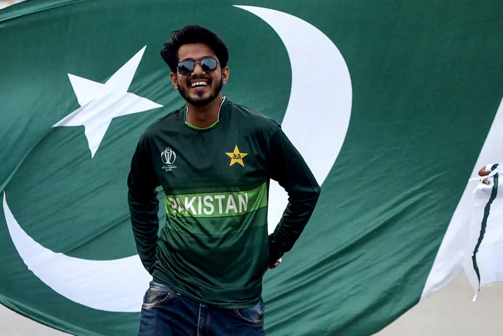 Smiling: a cricket fan poses for pictures with the Pakistan flag outside the National Cricket Stadium in Karachi, Pakistan.
