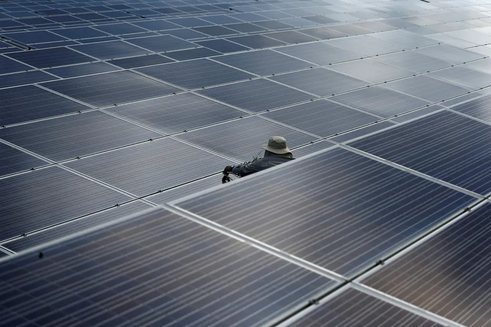 Rewenable energy: a worker at a solar power plant by Superblock in Phetchaburi province, Thailand