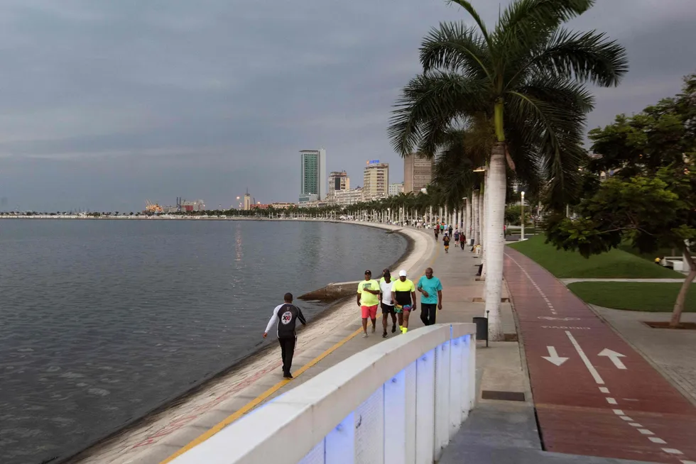 Deal afoot: people walk along the Marginal on the edge of Luanda Bay in Angola