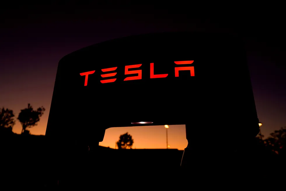 En Tesla lader i solnedgang i California