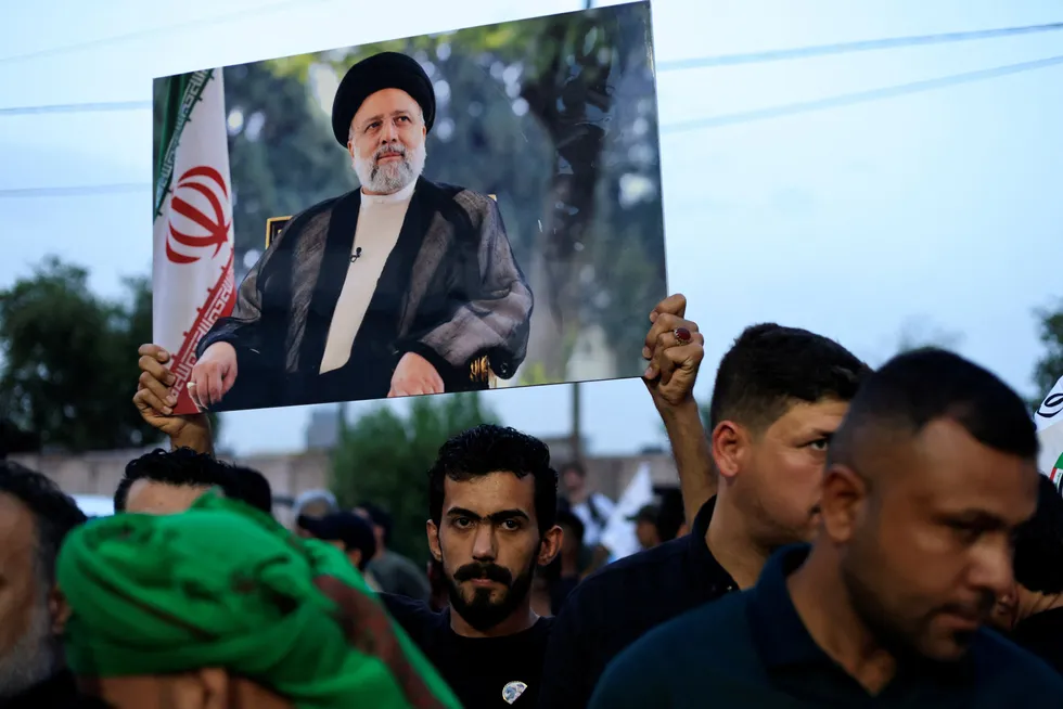 Iraqi supporters offer condolences over the death of Iran's President Ebrahim Raisi outside the Iranian embassy in Baghdad.