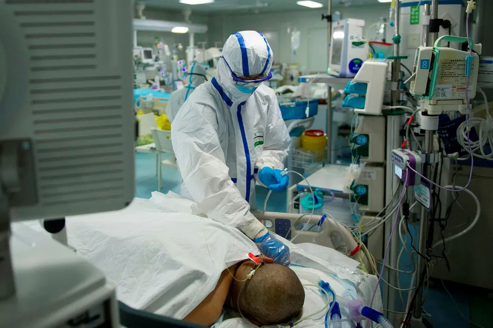 Det er kombinasjonen av en ekstrem rask smittespredning og relativt høy dødelighet som gjør koronaviruset så farlig. Dette er bildet fra et sykehus i Wuhan, der en pleier sjekker en koronasyk pasient.
