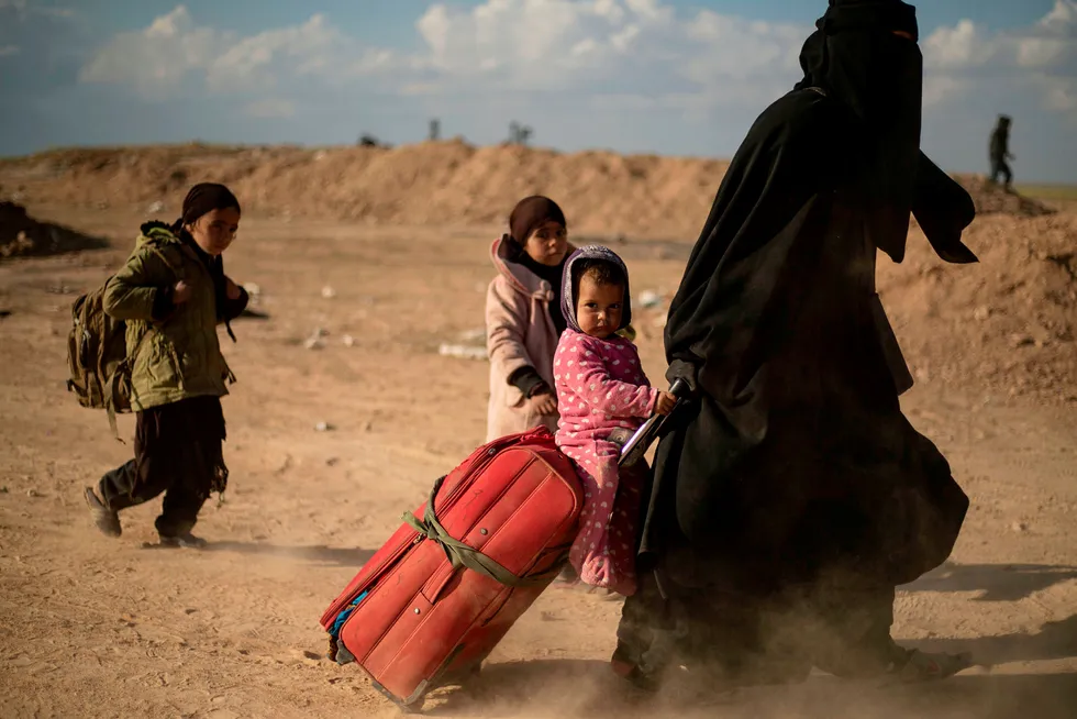 En kvinne og hennes barn flykter i mars ut Baghouz i mars som var det siste området terrororganisasjonen IS kontrollerte. Nå strever Norge og andre land med å finne ut i hvilken grad og hvordan de skal hjelpe barn av IS-medlemmer ut av flyktningleirer i Syria.