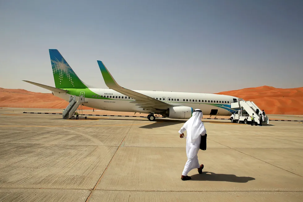 Flight plan: a worker walks towards an Aramco private plane in Saudi Arabia