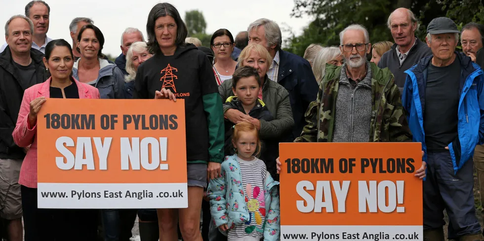 MP for Witham and former UK home secretary Priti Patel (front left) joins Rosie Pearson founder of Essex Suffolk Norfolk Pylons campaign group and other protesters, holding a sign against proposed pylons.