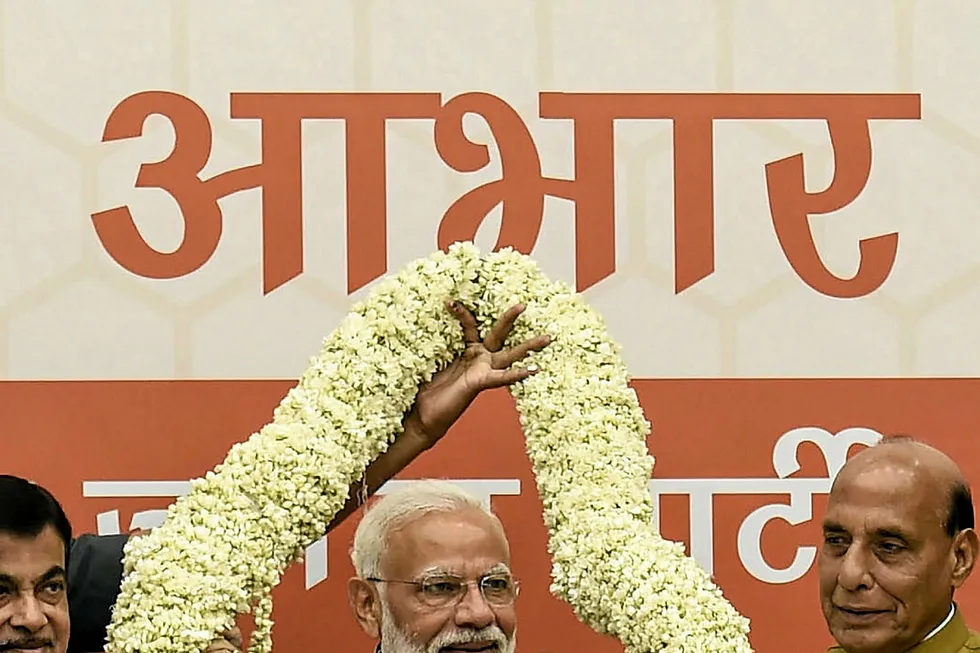 Return: Indian Prime Minister Narendra Modi gestures as he is garlanded during a ceremony in the country's India's general election