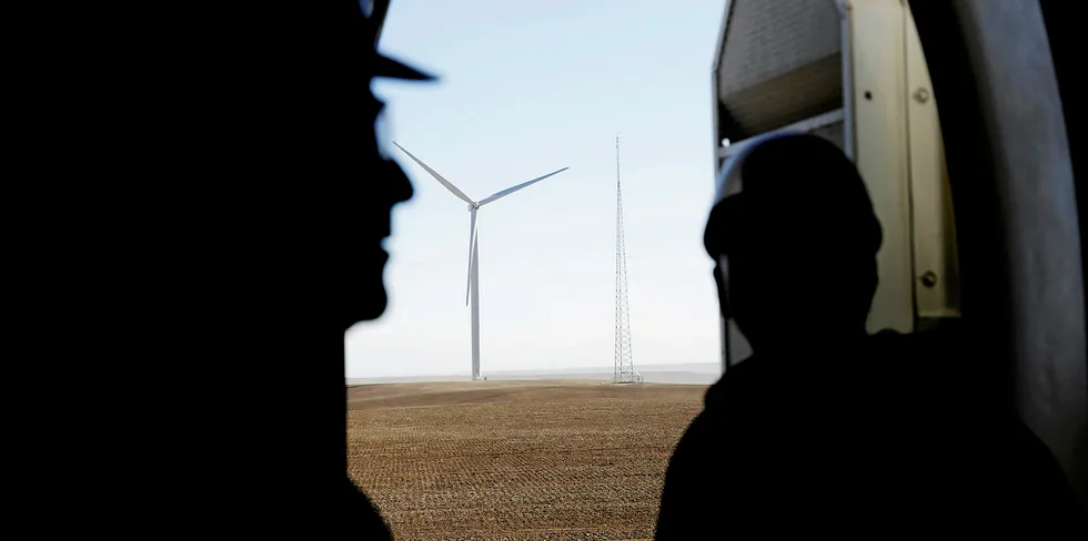 The silhouettes of employees are seen while finishing maintenance work inside the foundation of a wind turbine at the Caithness Shepherds Flat wind farm in Arlington, Oregon, US.