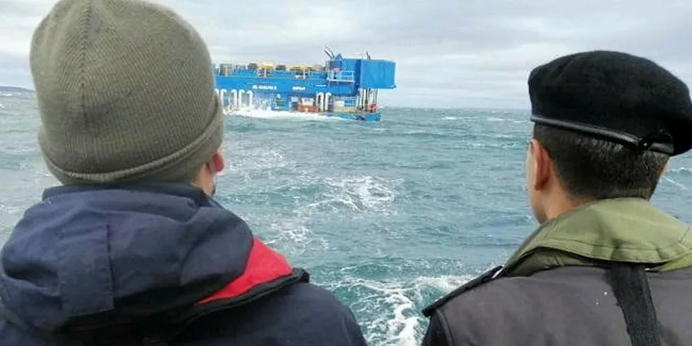 Representanter for chilenske myndigheter ved fôrflåten ved Caicura-anlegget etter at mærene med mesteparten av fisken sank til nesten 300 meter.