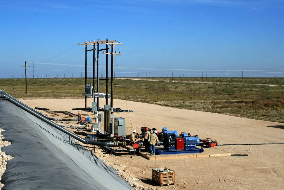 Tapping in: workers make adjustments to a pump at one of three freshwater pits used to store water for hydraulic fracturing in Texas