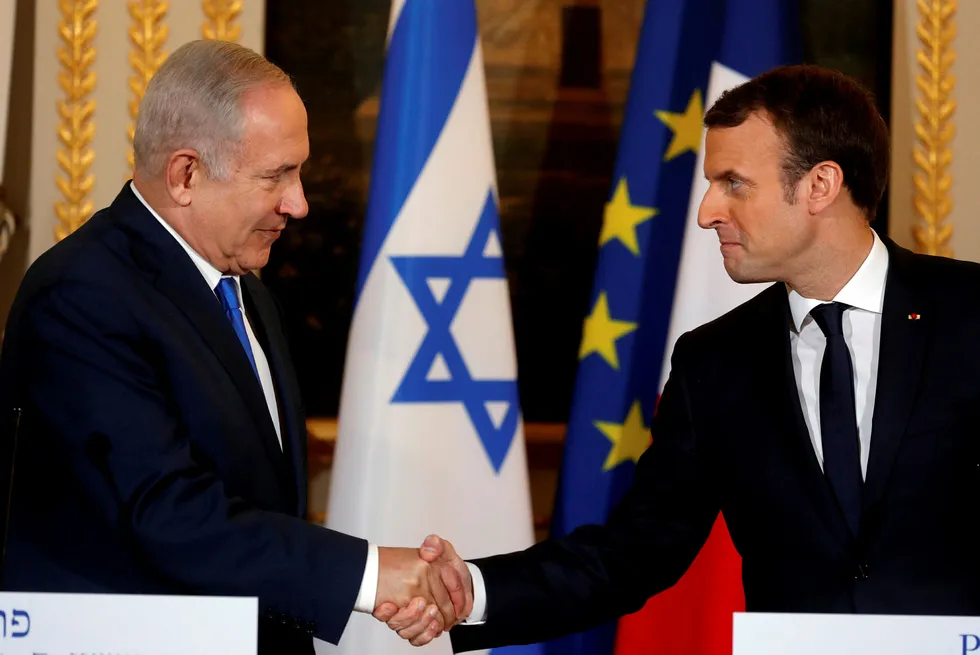 Israels statsminister Benjamin Netanyahu møter EU-ministre mandag. Her hilder han på Frankrikes president Emmanuel Macron i Paris søndag. Foto: Philippe Wojazer/Reuters/NTB scanpix