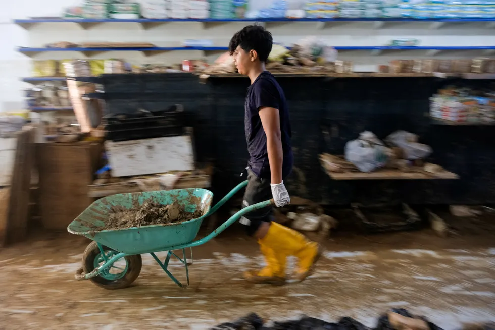 En gutt fjerner ødelagte varer fra en butikk etter flommen som i september i år ødela store deler av byen Derna, Libya. Klimaendringene gjør at det er behov for enorme investeringer i mange år.