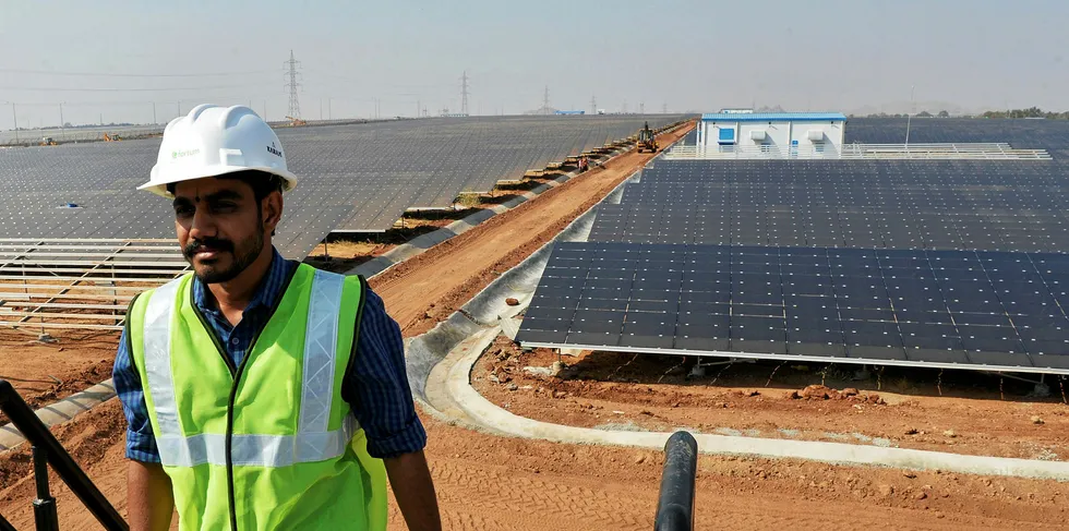 An Indian worker conducts routine checks of solar panels at "Shakti Sthala", the 2GW solar power park in Pavagada Taluk, situated about 150km from Bangalore.