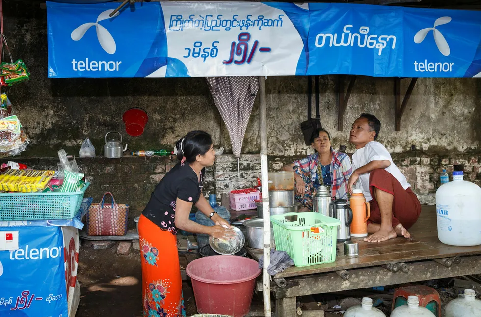 Telenor har teppelagt gatene i Myanmars største by Yangon med blå bannere, parasoller og skilt med synlig Telenor-logo. Foto: Heiko Junge/NTB Scanpix