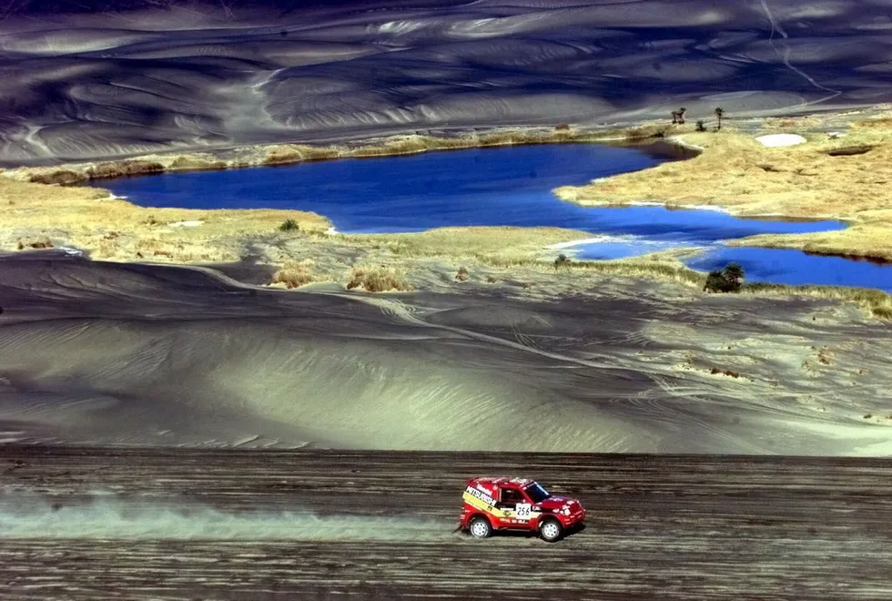 On the move: a car races through the Libyan desert between Waha and Waw el Kebir, Libya